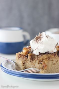 a piece of pie with whipped cream on top is sitting on a blue and white plate