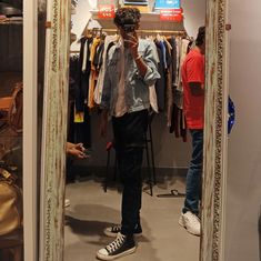 a man standing in front of a mirror taking a selfie