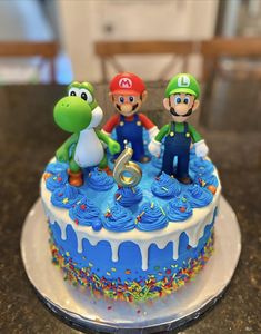 the cake is decorated with mario and luigi's birthday decorations on top of it