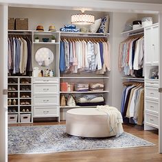 a walk in closet with white drawers and shelves filled with clothing, shoes and other items