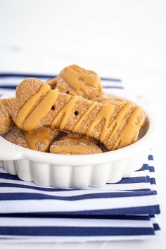 peanut butter pretzels in a white bowl on a blue and white striped napkin