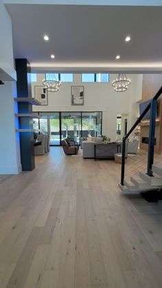 an empty living room with stairs leading up to the second floor and glass doors on both sides