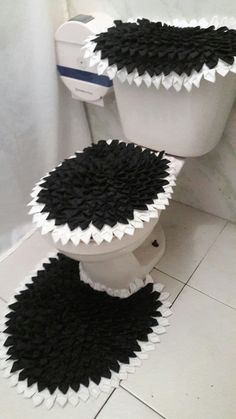 two toilets with black and white coverings on them