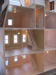 the inside of a doll house with stairs leading to two floors and three rooms on each level