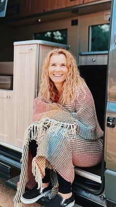 a woman sitting in the back of a truck