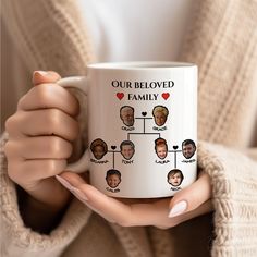 a woman holding a coffee mug with the family tree on it and hearts in her hands