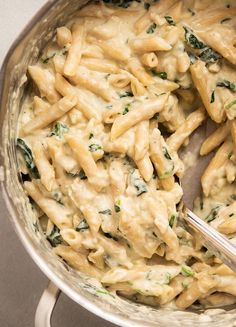 a large pot filled with pasta and spinach