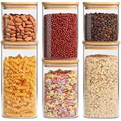 six glass containers filled with different types of cereals and nuts, all lined up in the same row