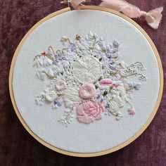 a close up of a embroidery on a piece of cloth with flowers in the center