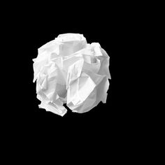 a black and white photo of an object made out of tissue paper on a black background