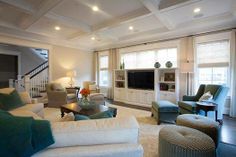 a living room with couches, chairs and a television on the wall in it