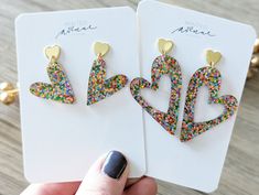 two pairs of heart shaped earrings with multicolored sprinkles on them