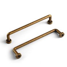 two brass colored handles on a white background