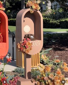 two mailboxes with flowers on them in the middle of a flowerbed garden