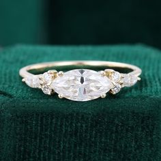 an oval cut diamond ring with three smaller round diamonds on the band, set in yellow gold