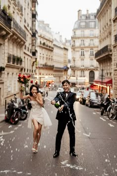 a man and woman are walking down the street with confetti in their hands