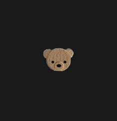 an embroidered teddy bear on a black background