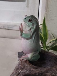 a frog statue sitting on top of a rock