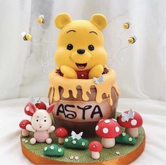 a winnie the pooh figurine sitting on top of a cake