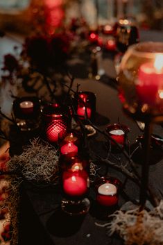 many lit candles are lined up on the table