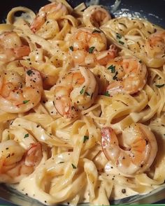 pasta with shrimp and parmesan cheese sauce in a skillet on the stove