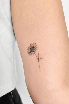 a small sunflower tattoo on the arm