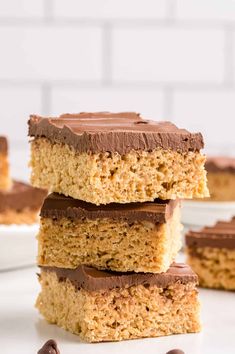 three pieces of peanut butter bars stacked on top of each other with chocolate frosting