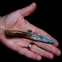 a person's hand holding a small knife in their palm