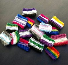 small knitted wristbands are laid out on a table top, with the colors of the rainbow in them