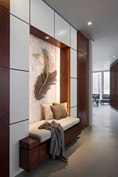 a modern living room with white walls and wood paneling, along with a couch