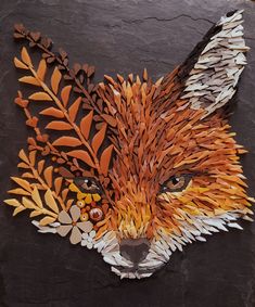 a close up of a paper cut out of a fox's head with leaves on it