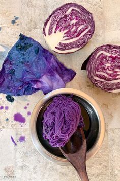 purple cabbage in a bowl with a wooden spoon next to it on a counter top