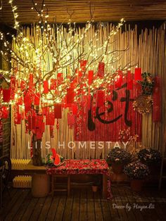 a room filled with lots of red decorations and lights hanging from the ceiling next to a wooden floor