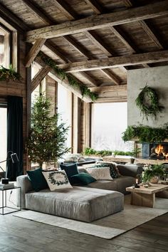 a living room filled with lots of furniture and christmas tree in the middle of it