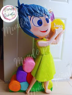 a doll with blue hair holding a toy in front of a pile of plastic toys