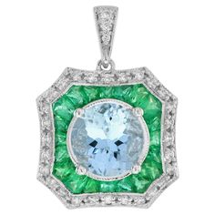 This elegant pendant is centrally set with a sparkly 8 carat aquamarine which is milgrain set. The aquamarine is then surrounded by a target of French cut vibrant green emeralds and glittering diamonds, similarly finished with a milgrain edges. The target hangs from a polished white gold bail. This classic beautiful pendant could be worn for a variety of occasions. Pendant Information Style: Art Deco Metal: 18K White Gold Width: 16 mm. Length: 22 mm. (length excludes chain) Weight: 4.98 g. (appr Emerald Art Deco, Emerald Art, Art Deco Pendant Necklace, Art Deco Metal, Style Art Deco, Art Deco Pendant, French Cut, Elegant Pendant, Estilo Art Deco