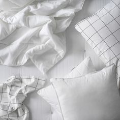 white pillows and blankets are laid out on the bed