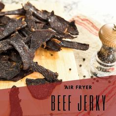 an air fryer beef jerk is on a cutting board next to a pepper shaker