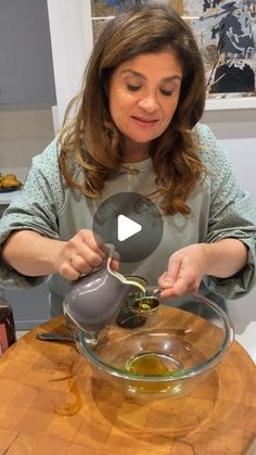 a woman pouring olive oil into a bowl