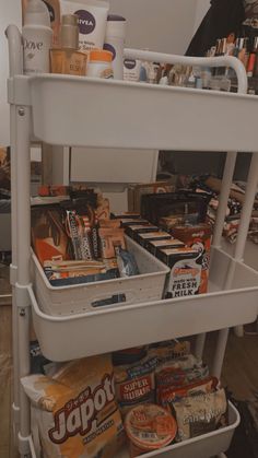 a white cart filled with lots of food and drinks on top of a hard wood floor