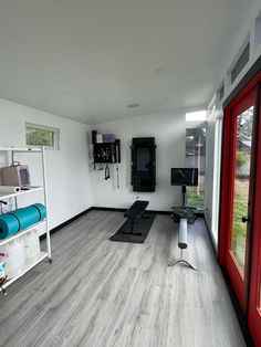 an empty gym room with yoga mats on the floor and exercise equipment in the corner