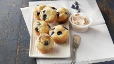 some blueberry muffins are on a plate with a cup of ice cream