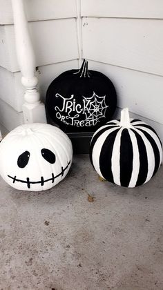 three pumpkins painted to look like jack - o'- lanterns on the porch