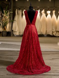 a red dress is on display in front of wedding gowns and other bridal gowns