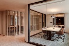 an office meeting room with wooden partitions and glass walls that divide the space from the dining area