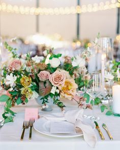 the table is set with flowers and silverware