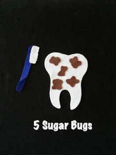 a toothbrush and some sugar bugs on a black surface