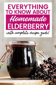 a jar filled with elderberry sitting on top of a wooden table