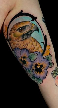 an owl and flowers tattoo on the arm