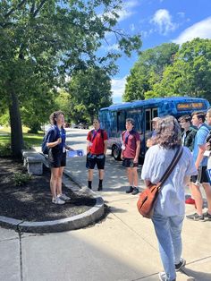 a group of people standing in front of a bus